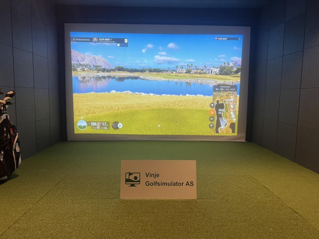 Golftrening med simulator hos Vinje Golfsimulator AS, realistisk landskap på stor skjerm, innendørs.