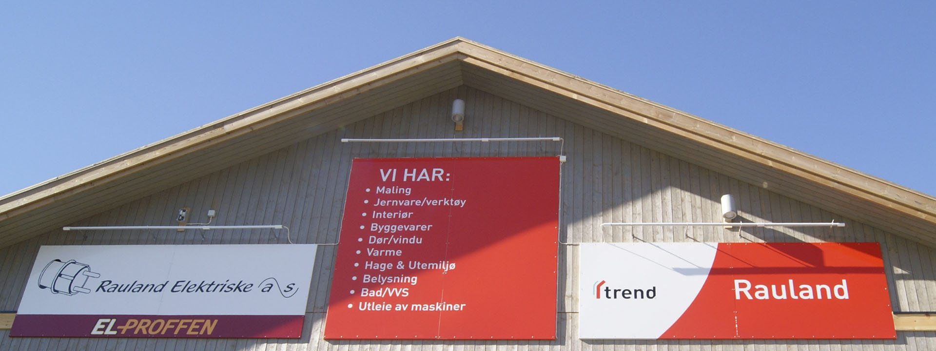 Rauland Elektriske AS skilt med tjenester: maling, jernvare, byggvarer, belysning, utleie av maskiner.
