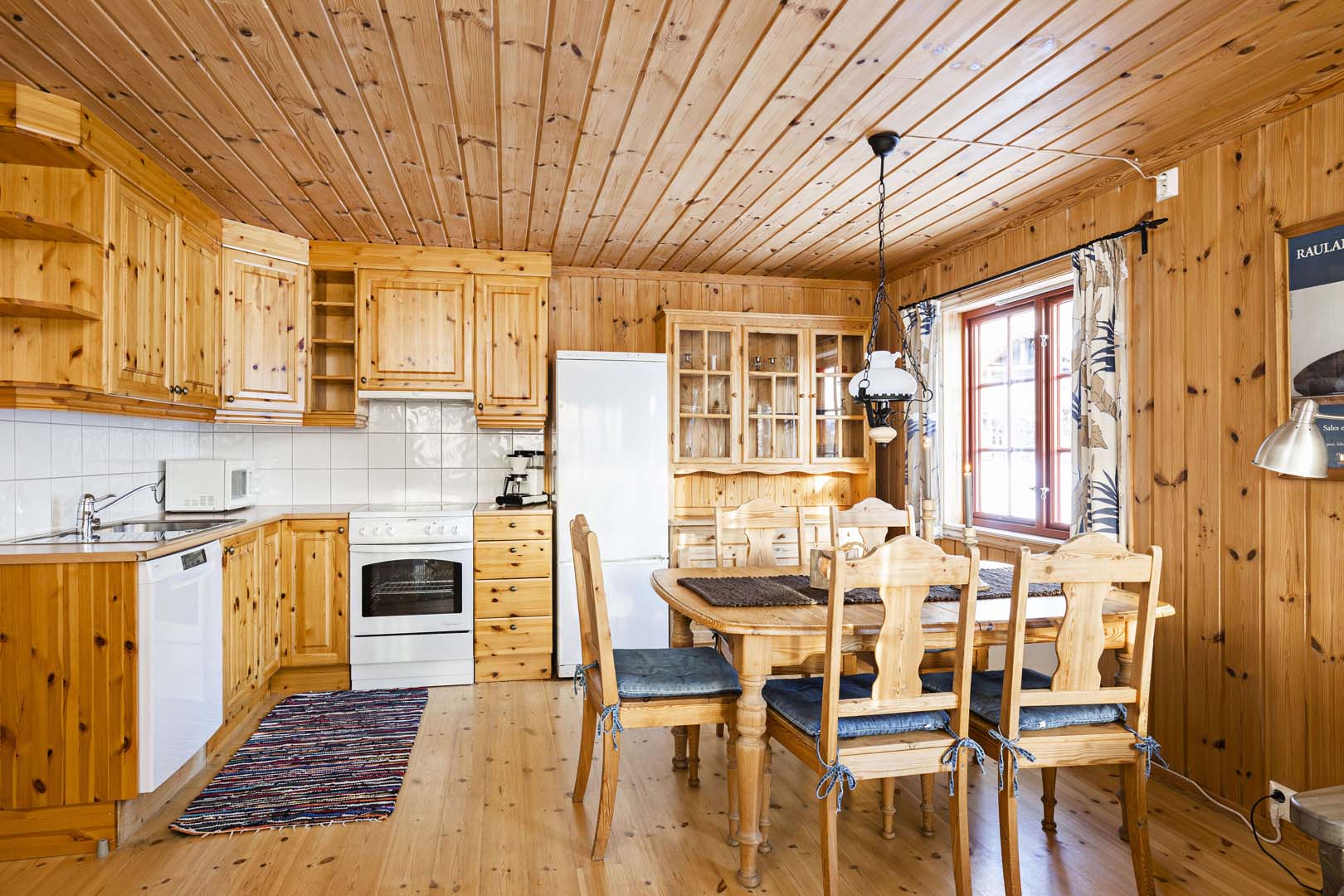 Koselig trekjøkken med spisebord, hvitevarer og vindu. Perfekt for hyttefølelse.