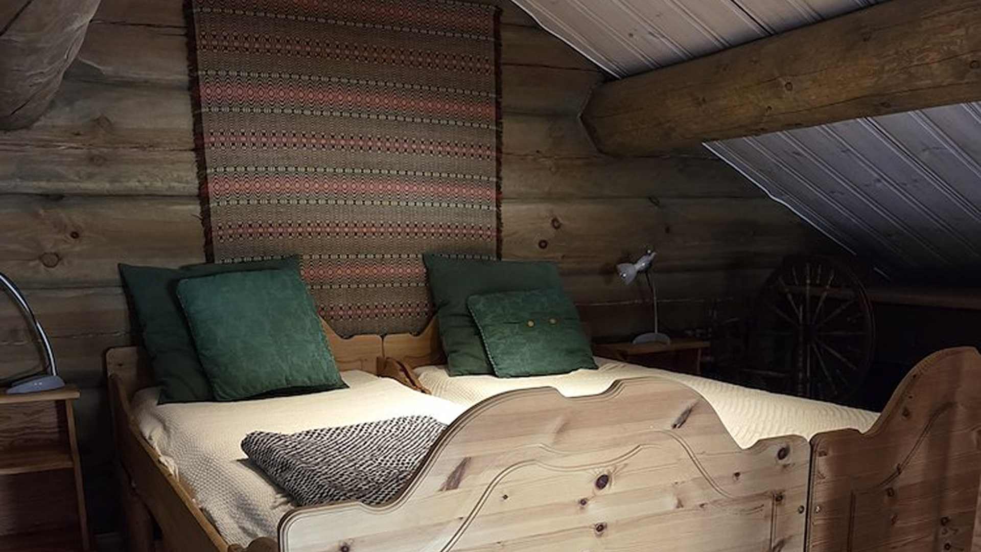 Sjarmerende soverom med tremøbler, grønne puter og et teppe i en koselig loftsstil. Ideelt for avslapning.