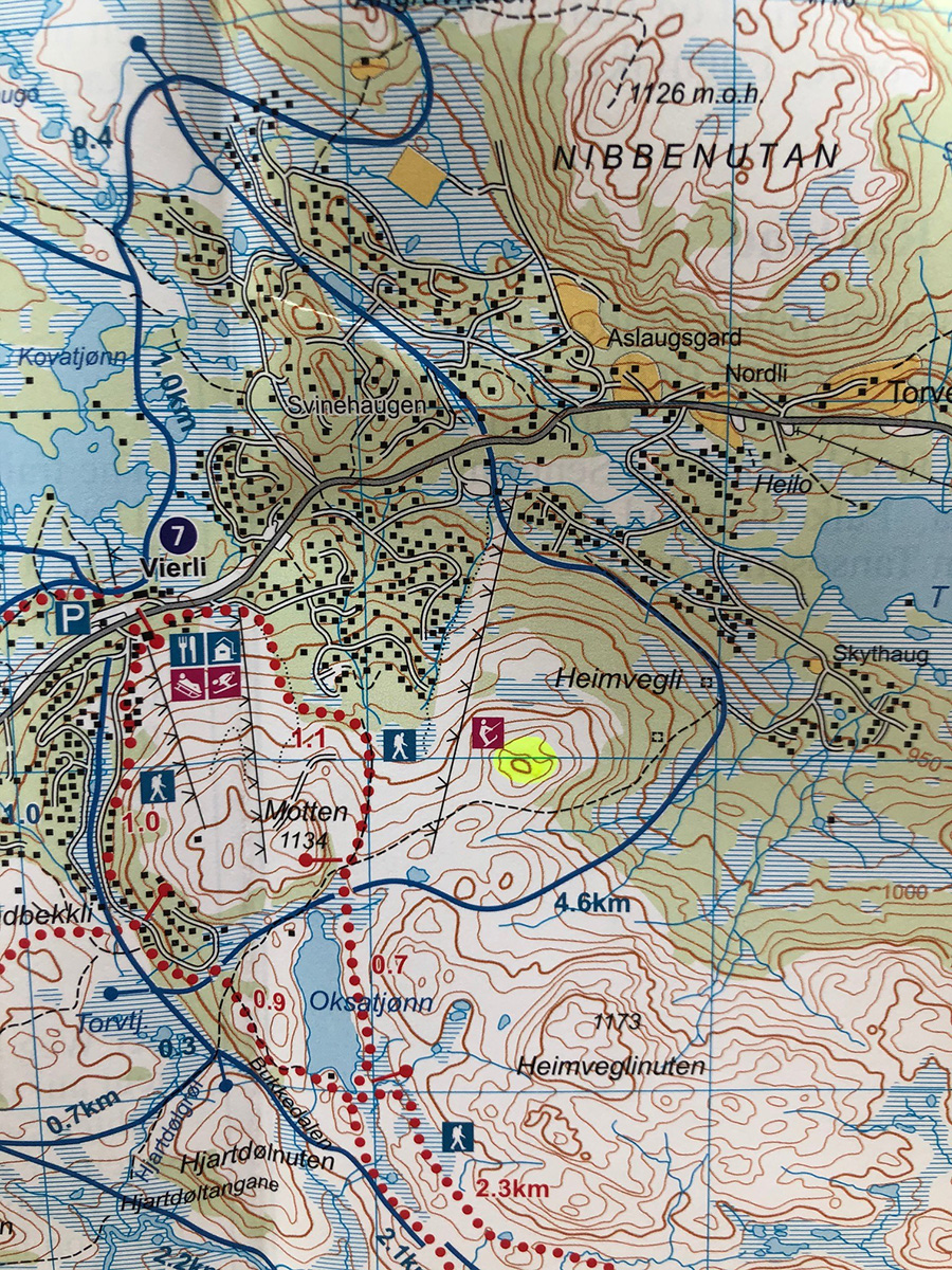 Snødekte hytter i norsk vinterlandskap med fjell i bakgrunnen. Perfekt for skiferie og vinteraktiviteter.