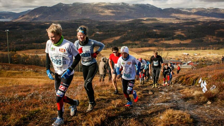 Løpere deltar i terrengløp i norsk fjellandskap med høstfarger og utsikt over dalen.