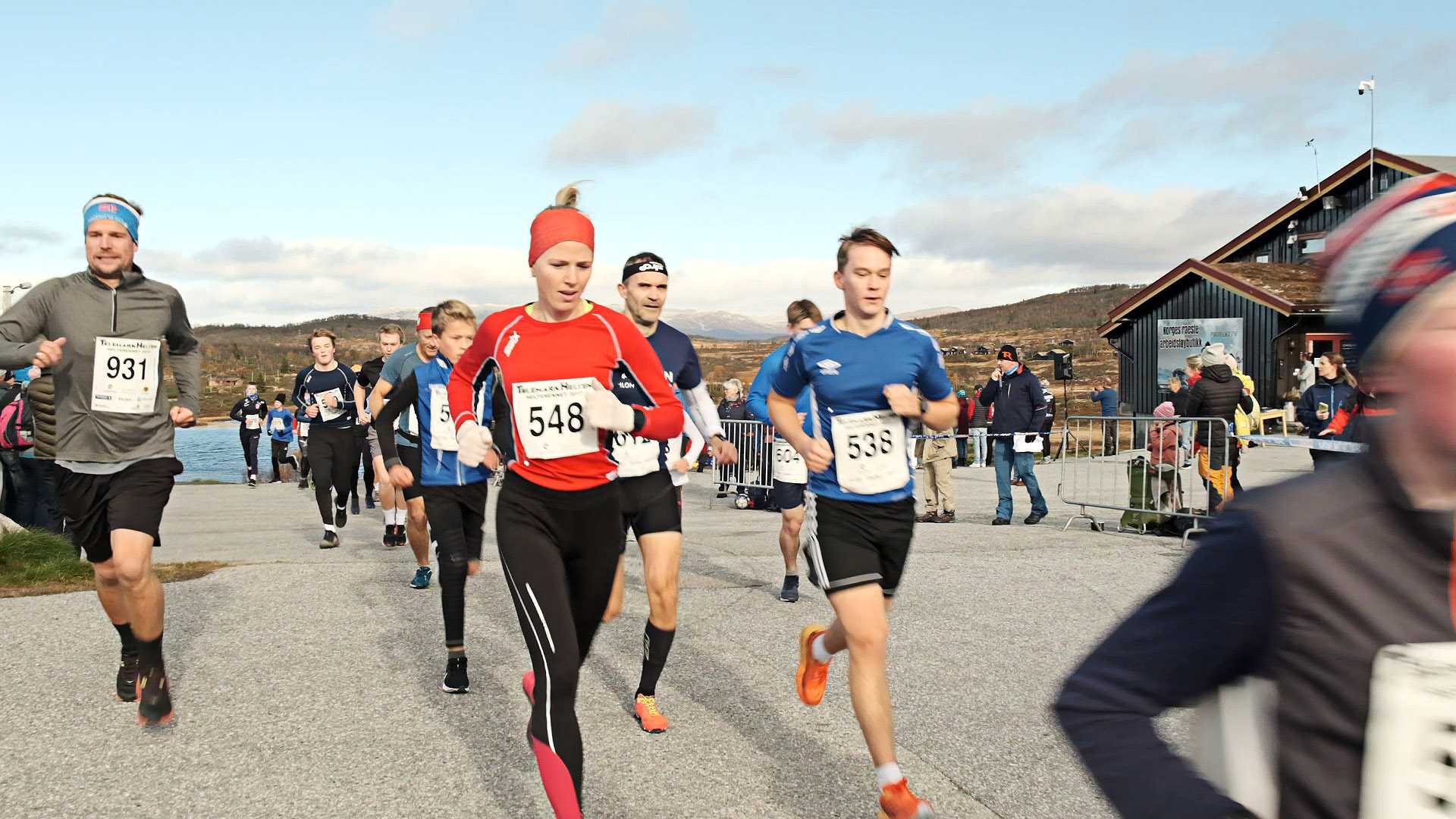 Løpere deltar i et maratonløp utendørs, klare til å konkurrere under klar himmel.
