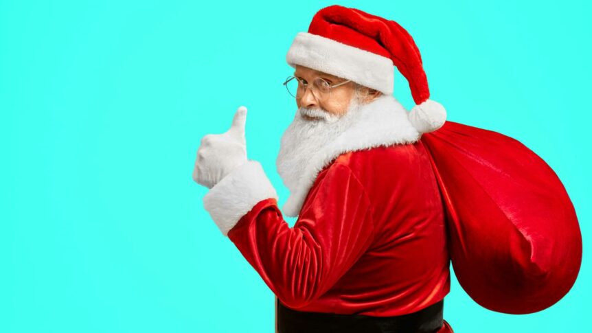 Julenisse med rød sekk gir tommel opp. Lyseblå bakgrunn. God julestemning!