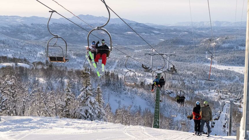 Skiløpere i skiheis ved snødekte fjell, klare for vintereventyr. Perfekt dag for skikjøring i fjellandskapet.