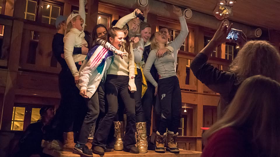 Ungdom danser og koser seg på afterski, mens en person tar bilder med mobiltelefonen.