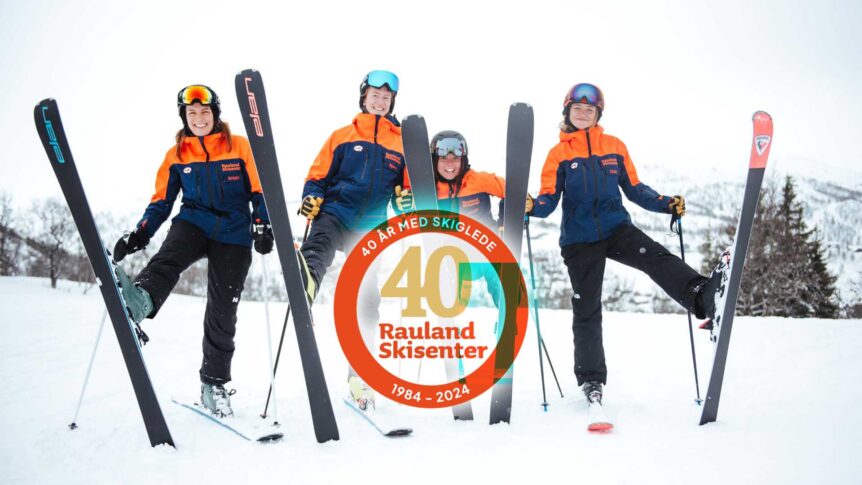 Gruppe skiløpere feirer 40-årsjubileum for Rauland Skisenter i snødekte fjell.