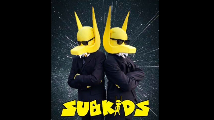 To personer i sorte dresser og gule masker står rygg mot rygg foran romlig bakgrunn, med teksten SUBKIDS.