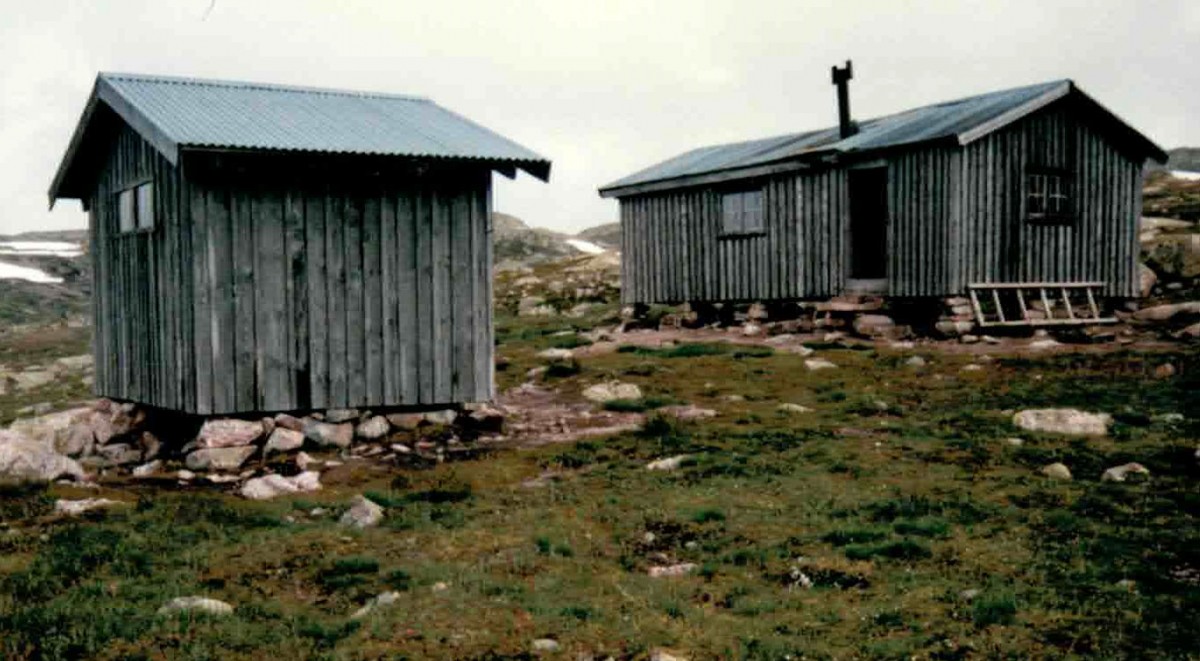 To fjellhytter i norsk landskap med stein og gress, perfekt for turer i naturen.