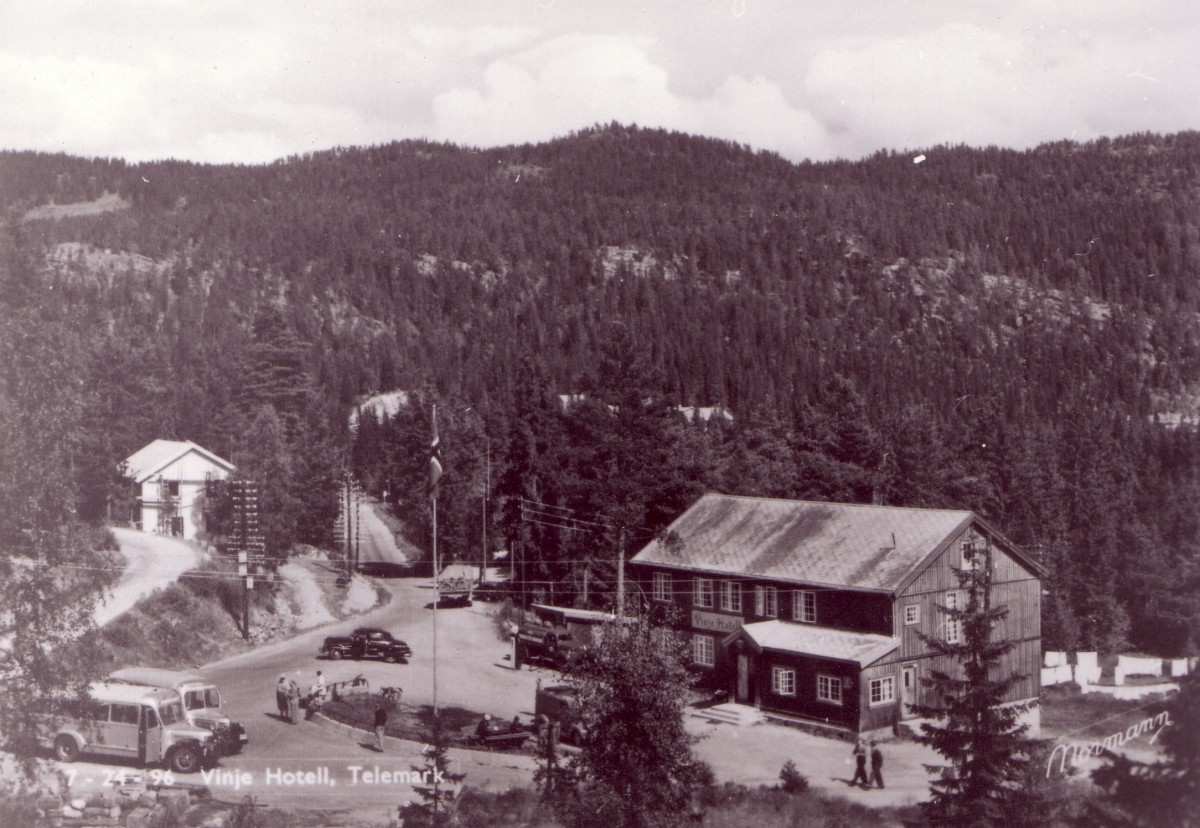 Svart-hvitt bilde av Vinje Hotell i Telemark, omkranset av skog og landskap i Norge.