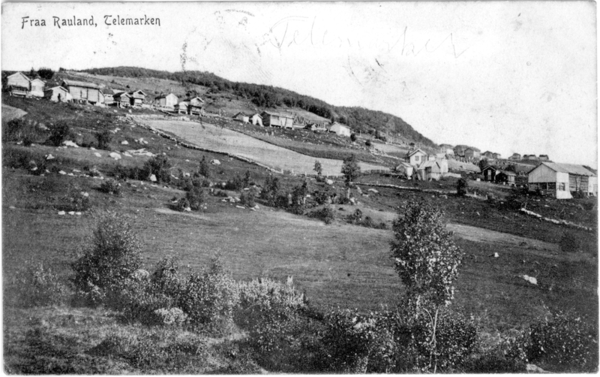 Svart-hvitt landskapsbilde av Rauland i Telemark, med hus og åser i bakgrunnen.