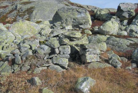 Steinformasjon i et fjellandskap med mose og gress. Rustikk natur i norsk fjellområde.