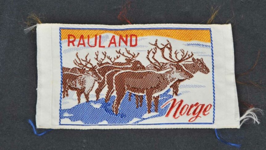 Bilde av et brodert motiv med reinsdyr fra Rauland, Norge. Tekst: Rauland Norge, tradisjonelt broderi.