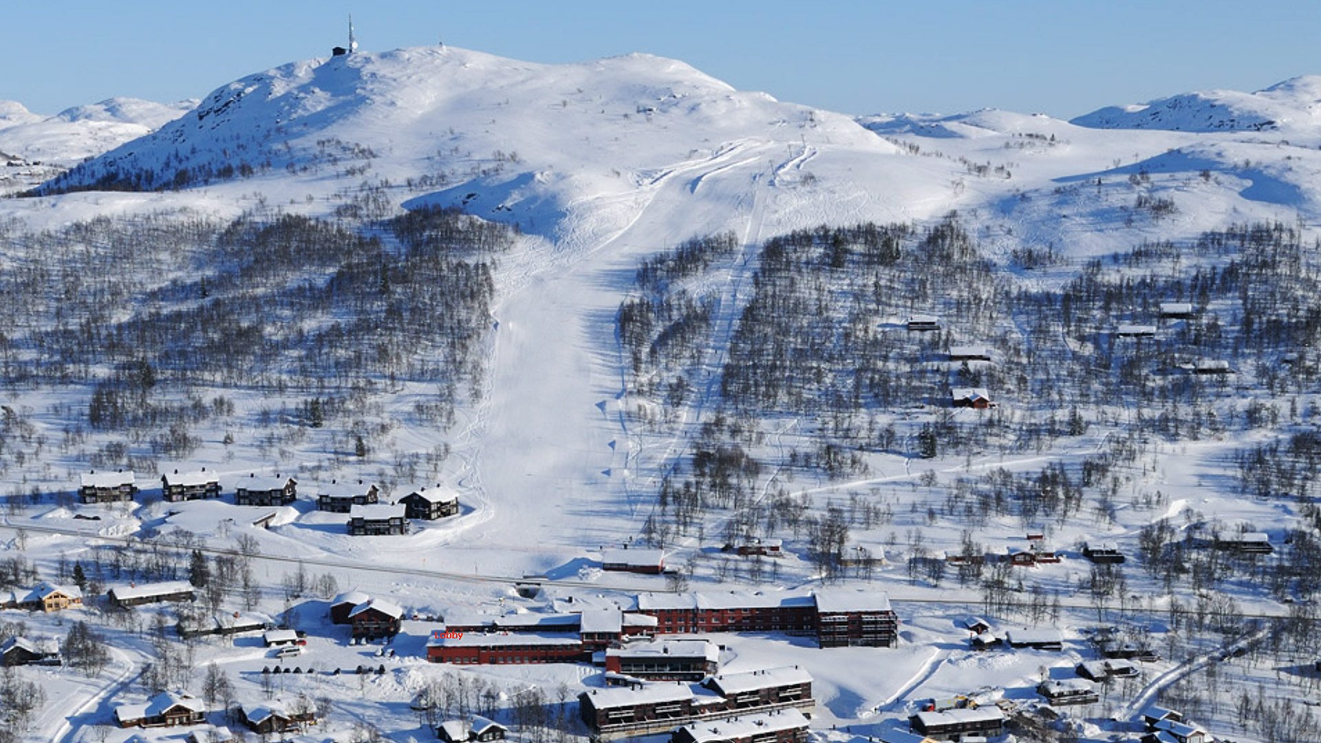 Snødekt fjellandskap med hytter og skispor i Vinter-Norge. Flott utsikt over dalen.