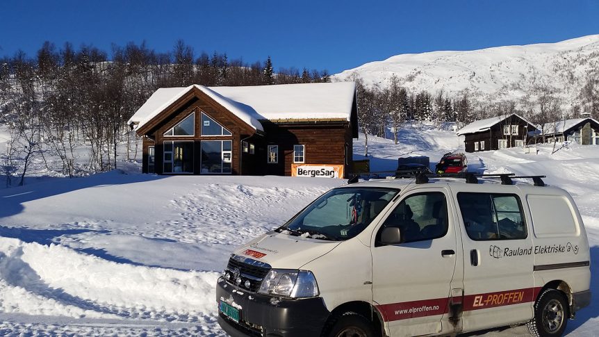 Hytte i snødekket norsk landskap med varebil fra Rauland Elektriske.