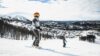 To personer står på ski med vakker vinterbakgrunn i fjellet.