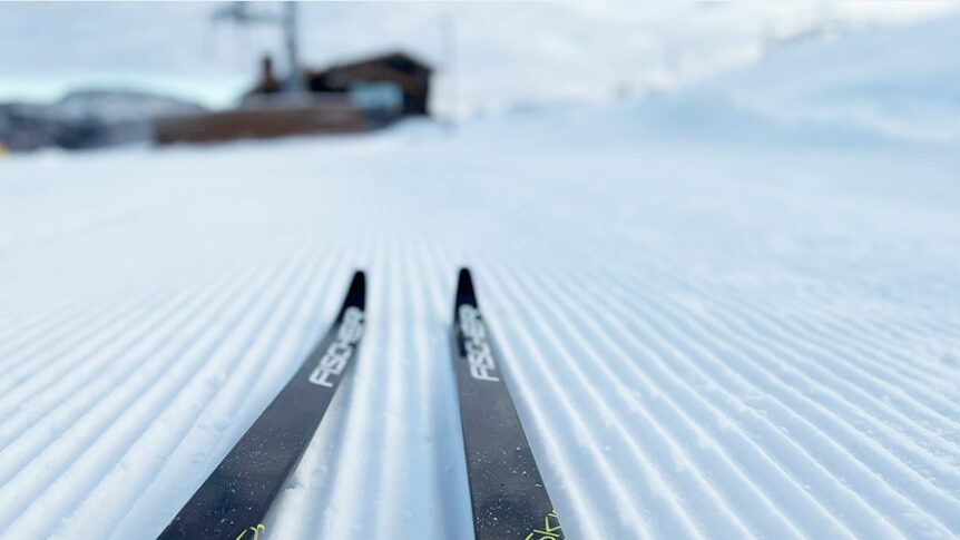Langrennsski på nyoppkjørt snøspor i fjellandskap, klar for vintereventyr.