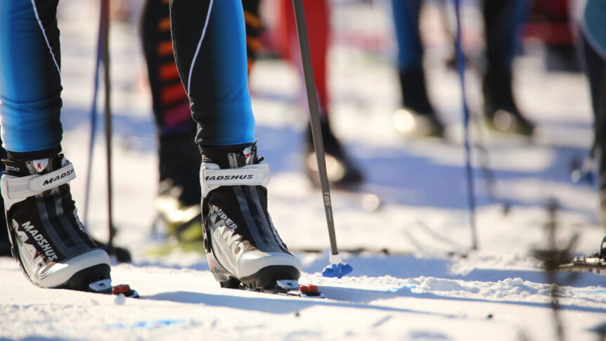Langrennsløpere på snødekt spor med skiutstyr i fokus. Vinteridrett i vakker natur.