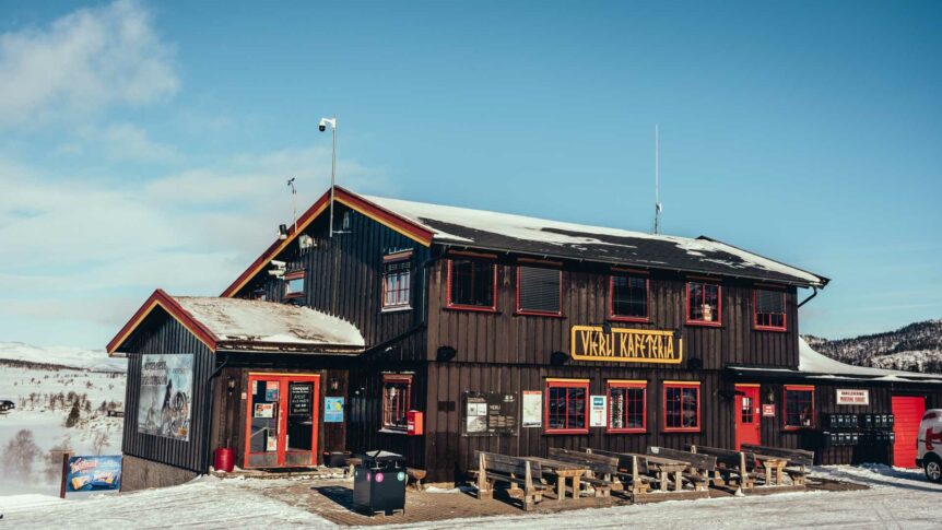 Vinterkafé i en fjellområde med snø og blå himmel, norsk fjellhytte.