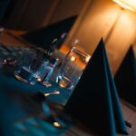 Koselig opplyst restaurantscene med dekket bord, servittholder og krystallklart glass.