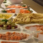 Smørbrødbuffet med laks, wraps, potetsalat og lefser på et festbord. Delikate retter til arrangementer.