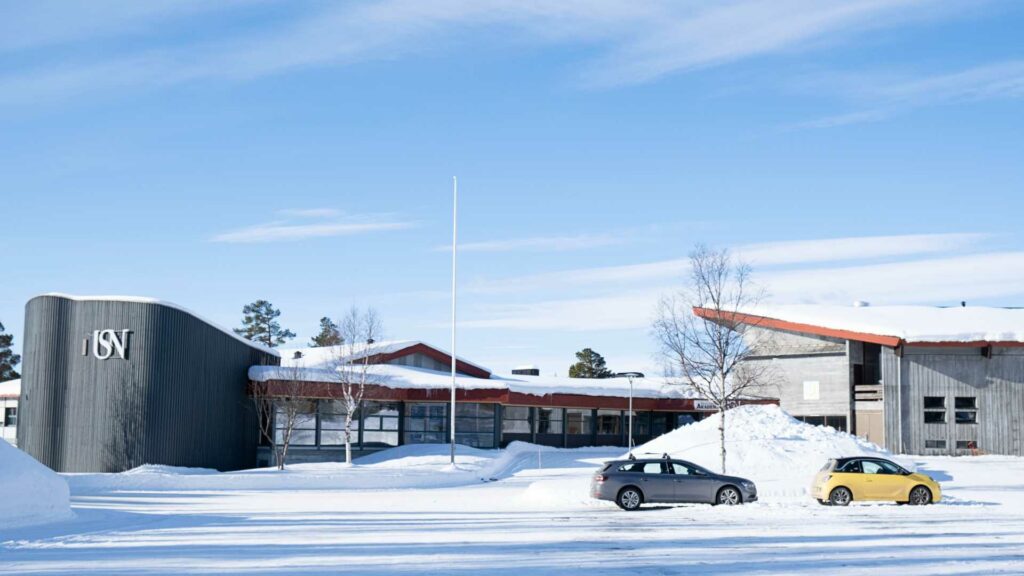 Bygning dekket av snø ved Universitetet i Sørøst-Norge, solfylt vinterdag.